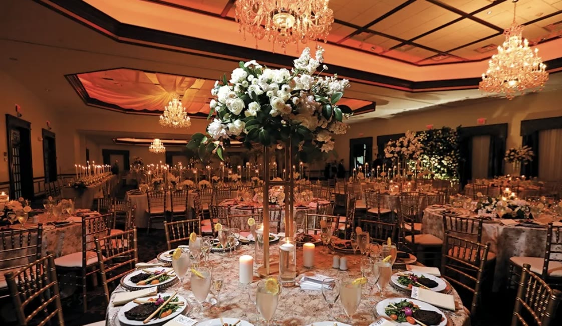 Grand Ballroom set for dinner with chandeliers, candlelight, and white floral centerpieces