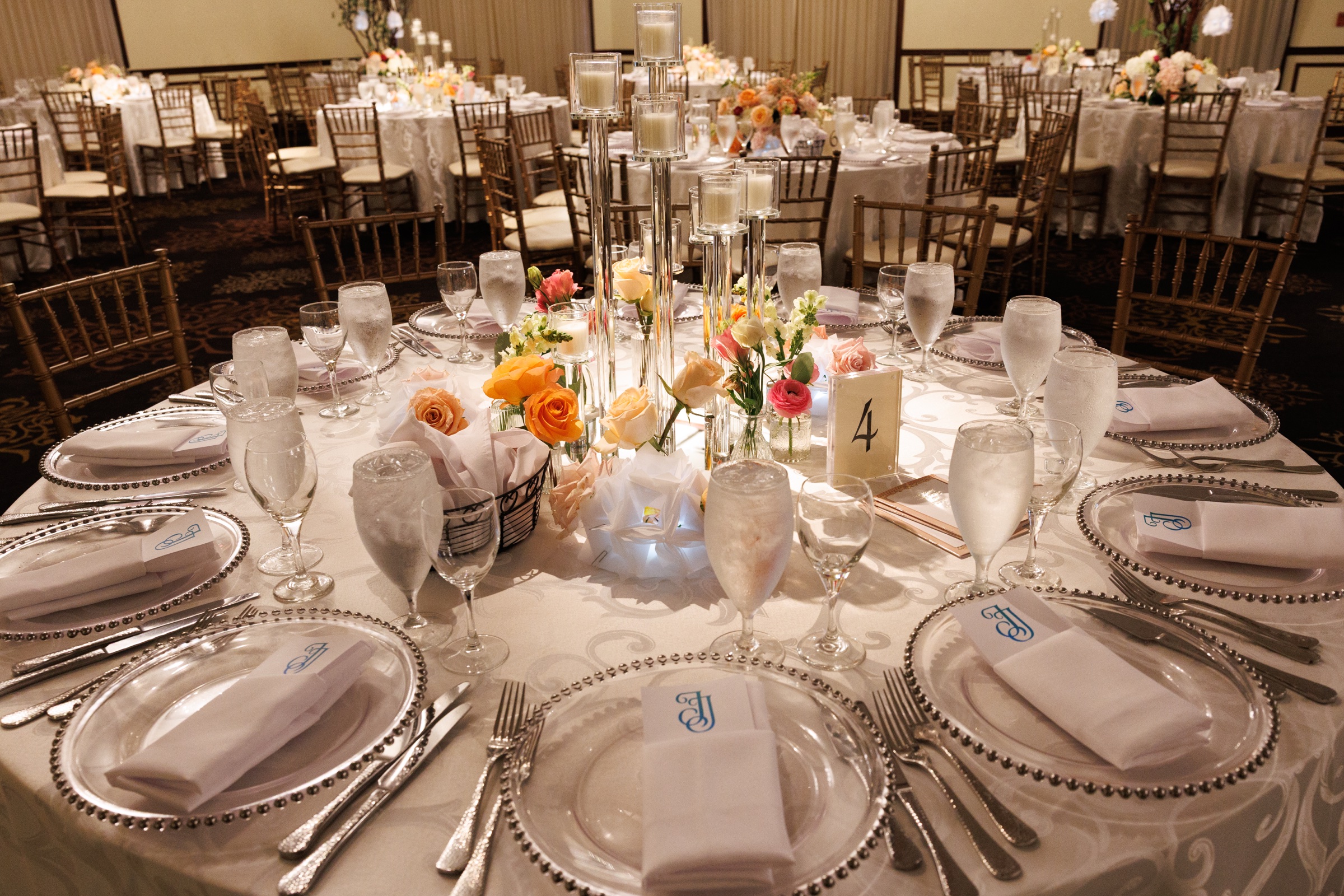 Grand Ballroom table set with candlelight, colorful flowers, and silver-rimmed place settings