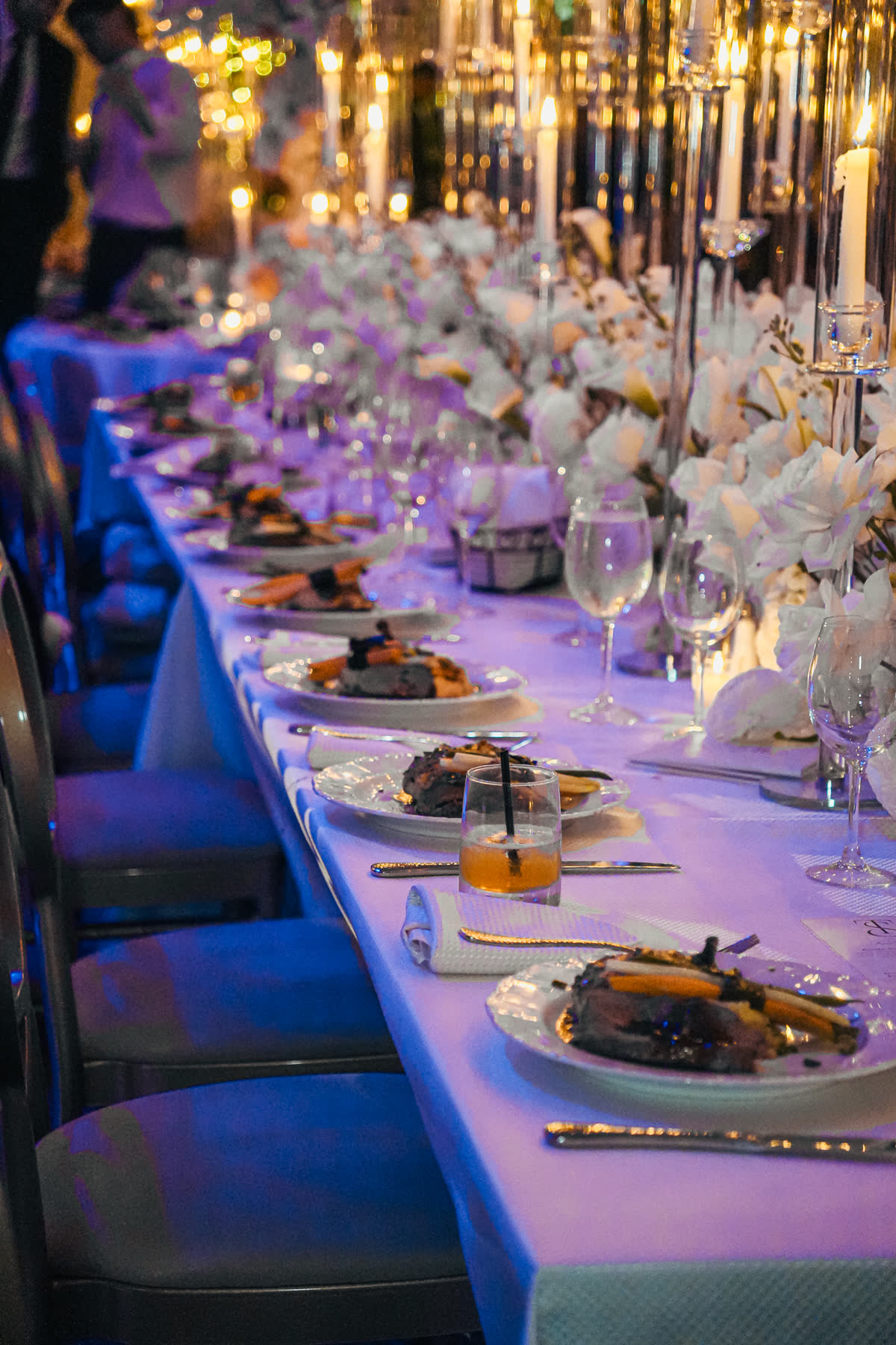 Blue-lit dinner room with plated kosher service