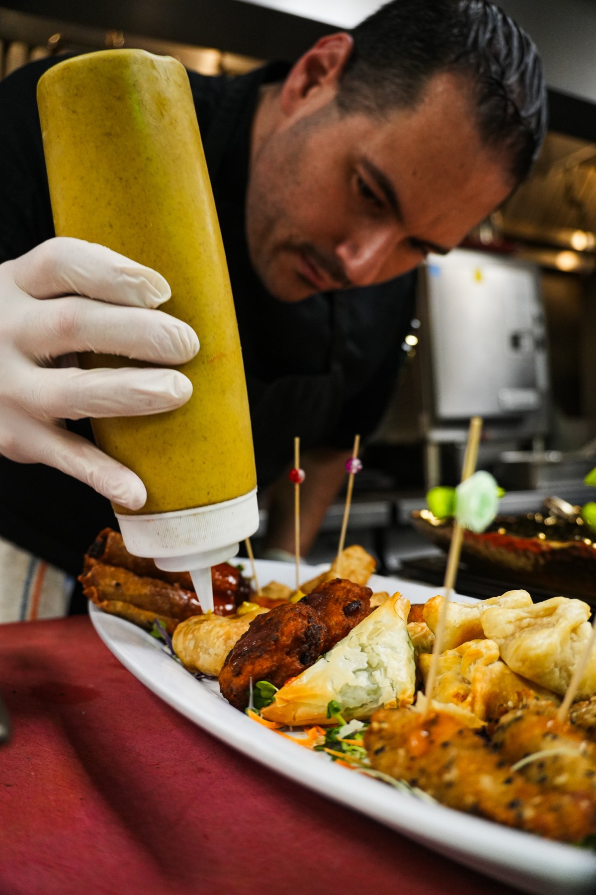 Chef finishing passed kosher bites with sauce