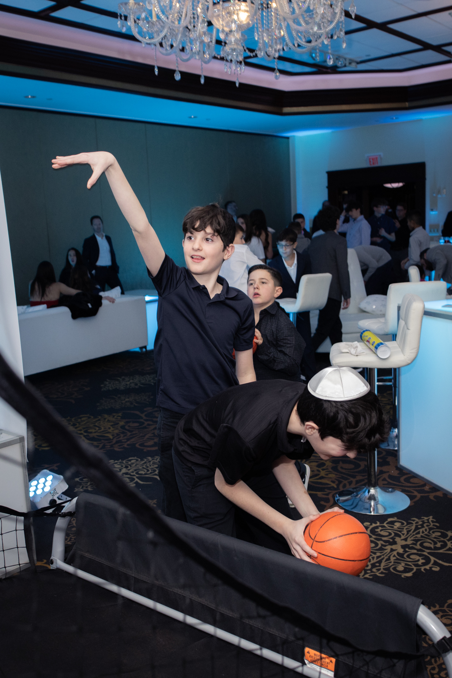Young guests enjoying a basketball game in the party lounge