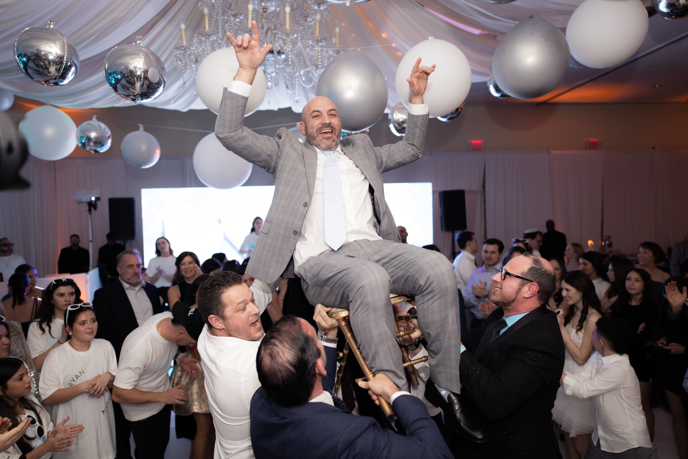 Guest lifted in a chair during a lively mitzvah celebration