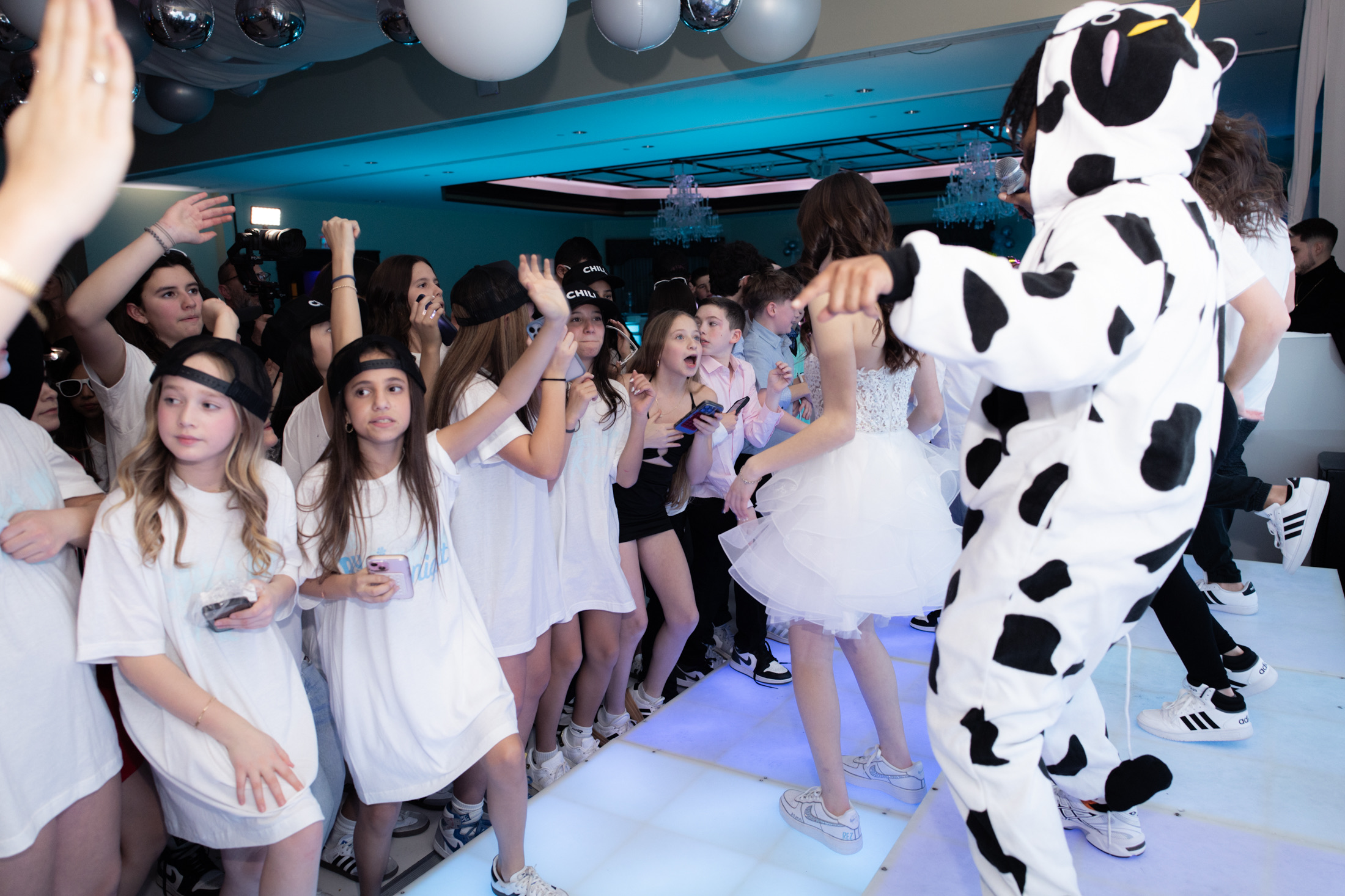 Young guests dancing together on the illuminated mitzvah dance floor