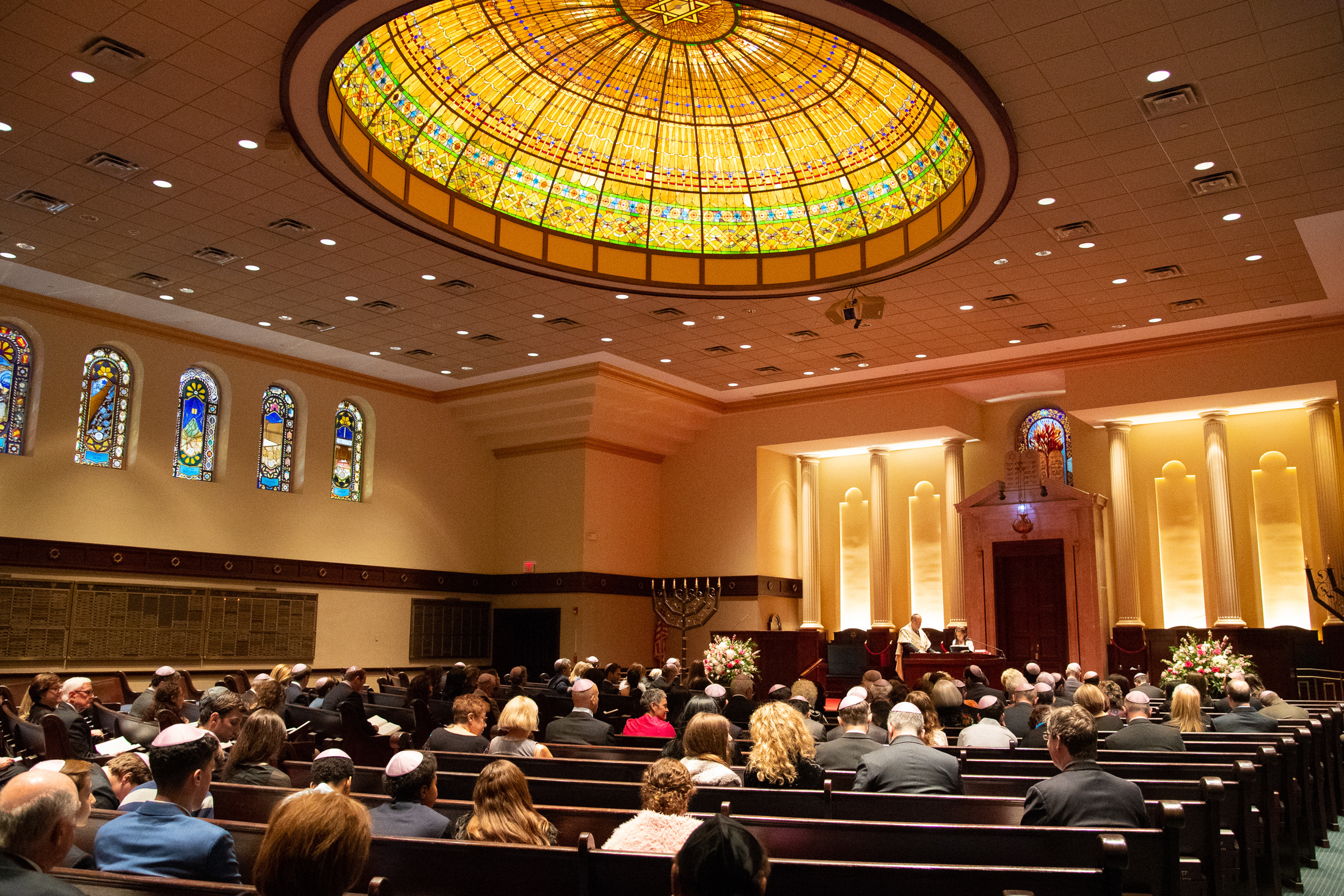 Family and guests gathered for a mitzvah service beneath the stained-glass dome