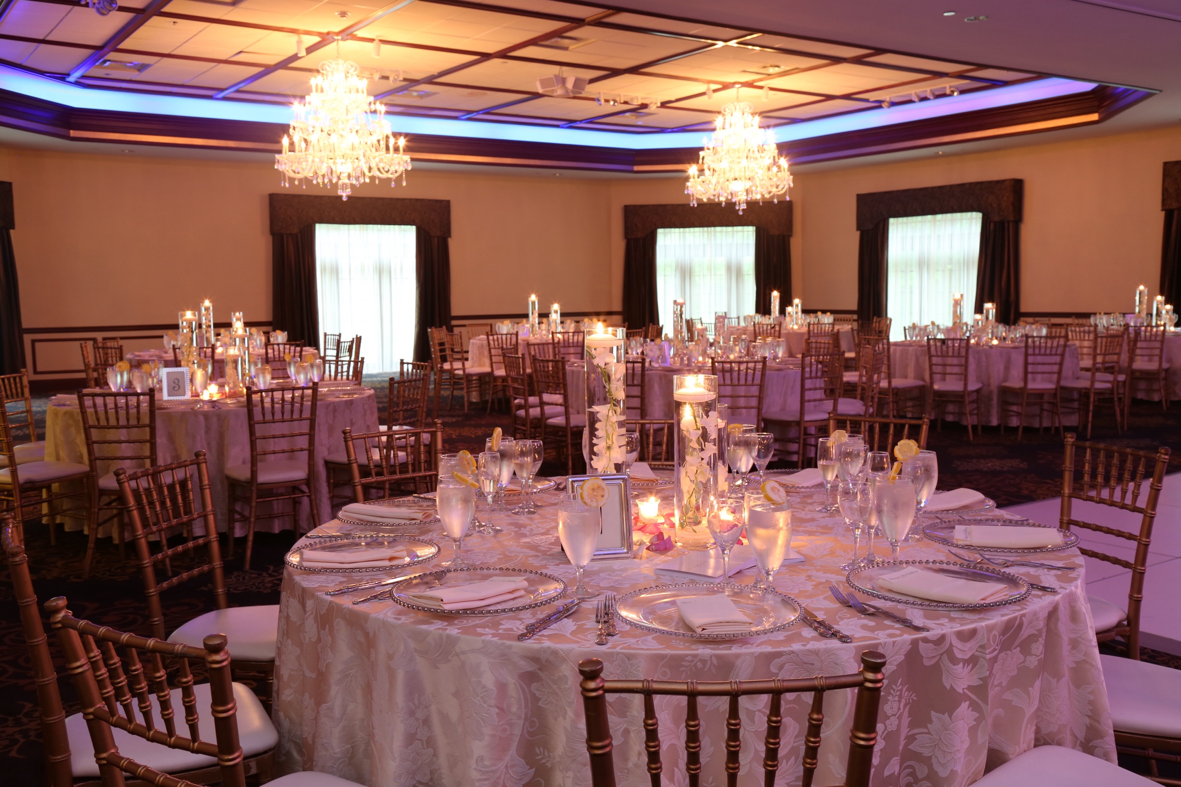 Grand Ballroom set with candlelit tables and warm chandelier light