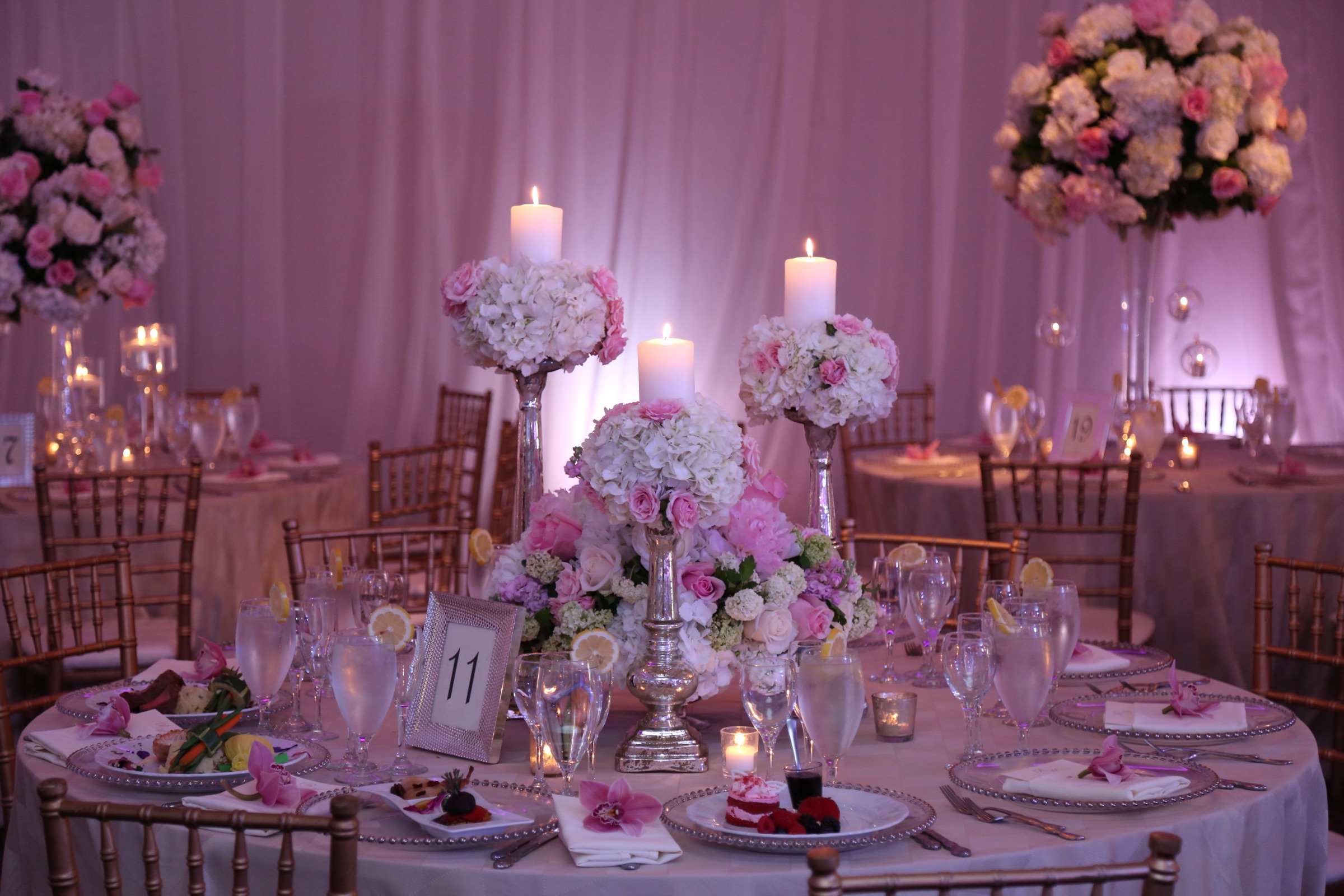 Candlelit pink and white floral centerpiece on a ballroom table