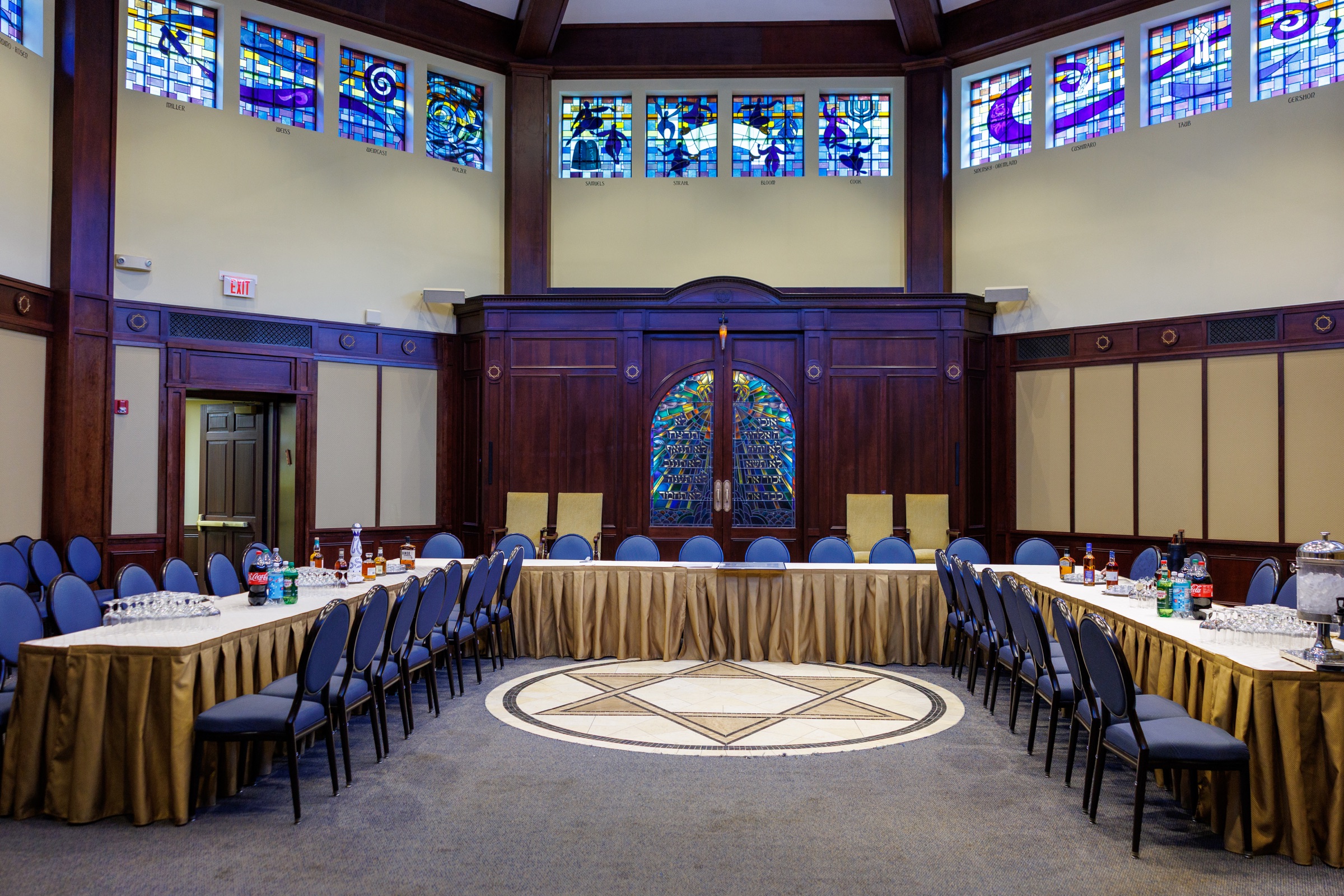 Tisch room arranged for a family gathering beneath colorful stained glass