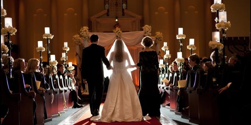 Bride walking down the ceremony aisle with family