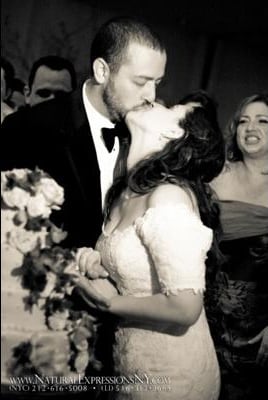 Bride and groom sharing a kiss during the wedding celebration